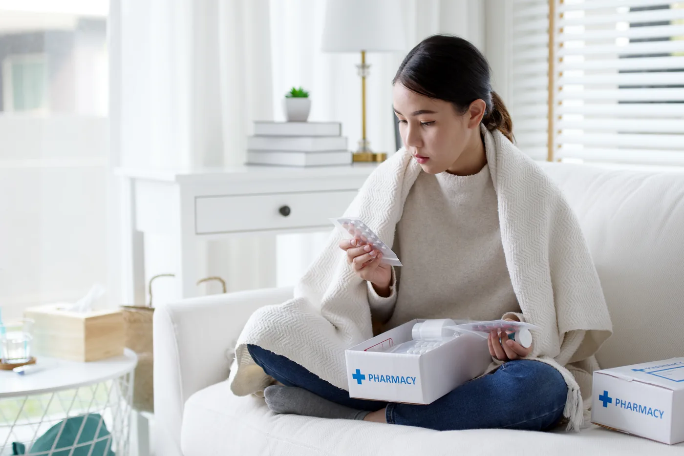 Woman at home opening a prescription delivery from the pharmacy