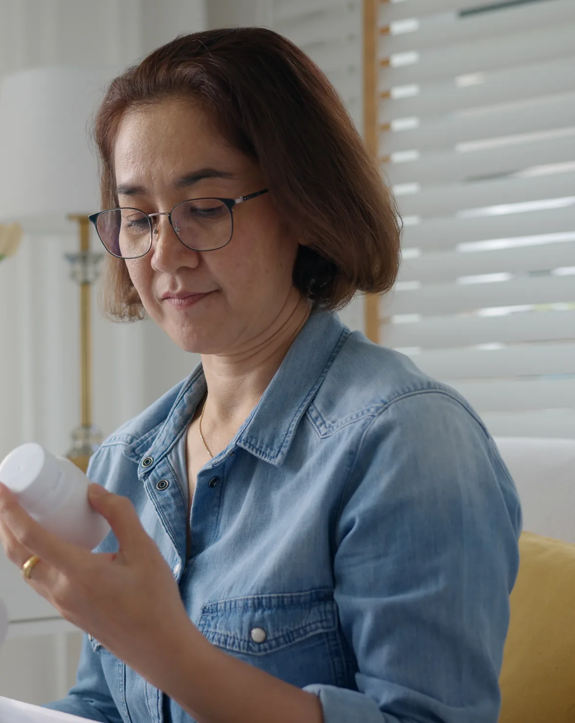Woman at home reading the label on her prescription