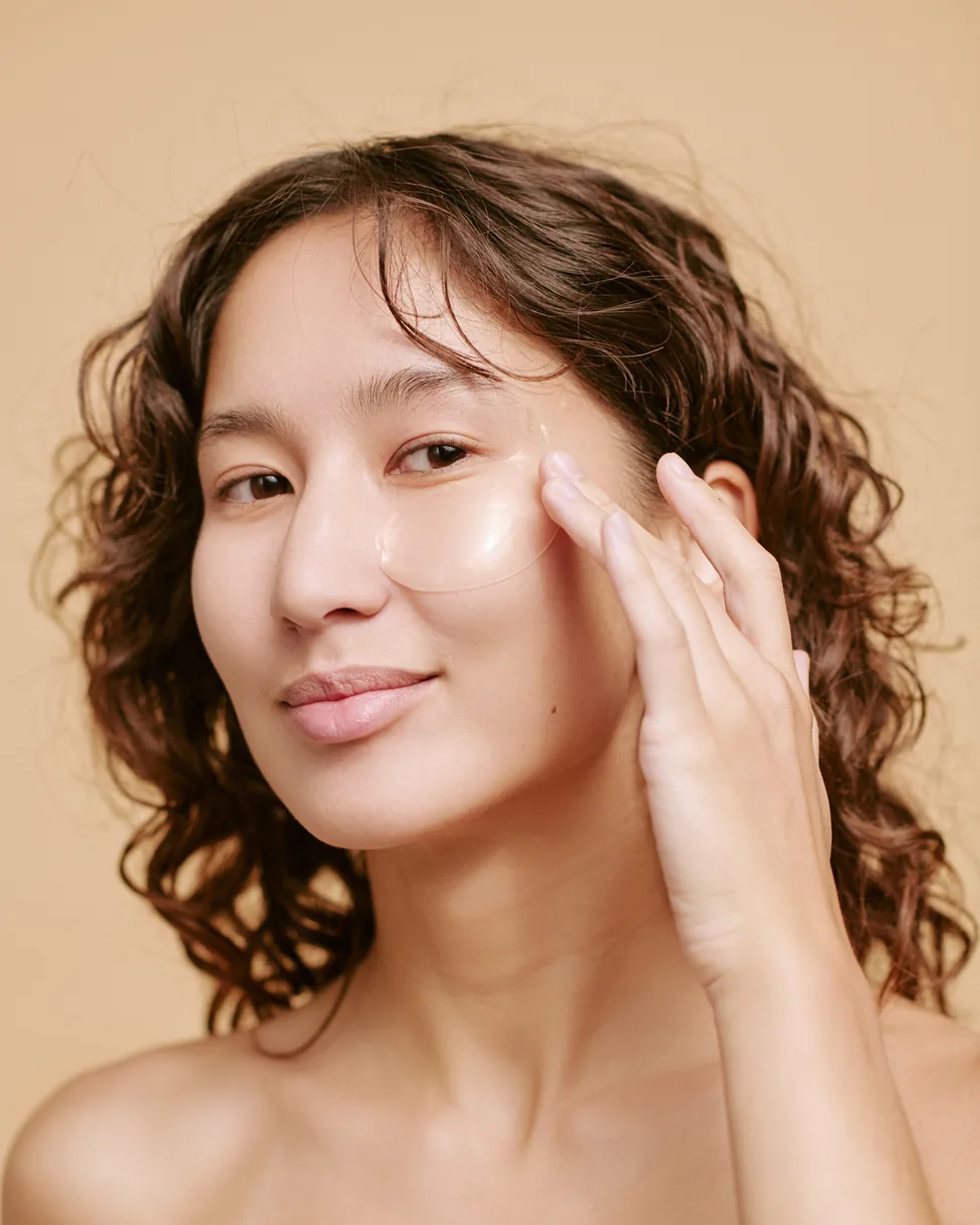 Woman applying skincare under her eyes